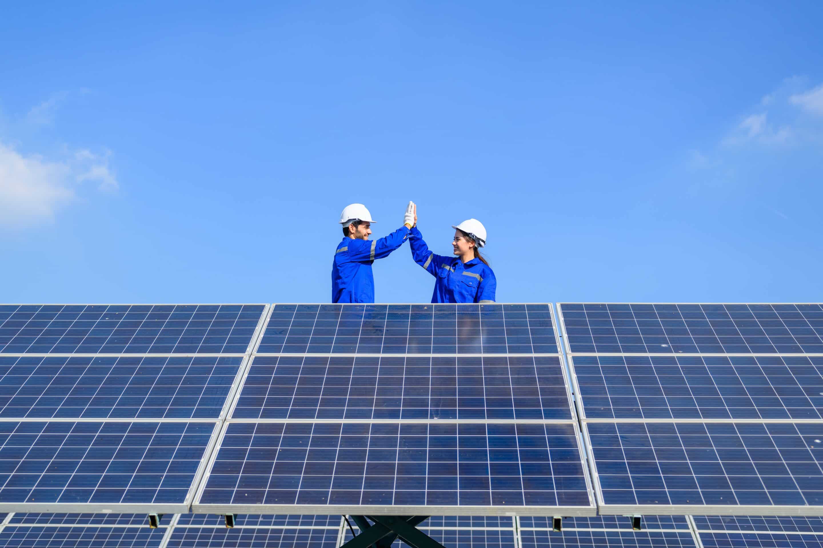 Zwei Energiesun Mitarbeiter klatschen ein nach Montage einer Photovoltaikanlage
